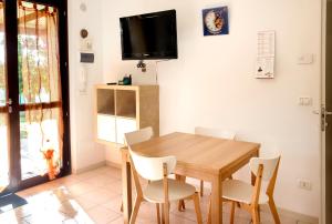 ein Esszimmer mit einem Holztisch und Stühlen in der Unterkunft M273 - Marcelli, nuovo trilocale con giardino in Marcelli