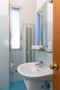 uma casa de banho com um lavatório branco e um espelho. em Hotel Royal em Giulianova