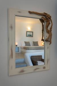 um espelho com um sofá e uma cama num quarto em Sirocos em Karavostasi