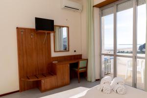 a room with a desk with a mirror and a window at Hotel Royal in Giulianova