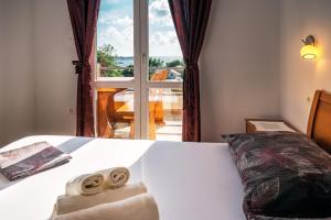 ein Schlafzimmer mit einem Bett mit zwei Handtüchern darauf in der Unterkunft Apartments Pitarević in Saplunara