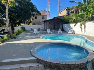 康塞桑達巴拉的住宿－Pousada Itaúnas，一座带椅子的游泳池以及一座建筑