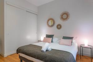 a bedroom with a bed with pink and white pillows at DIFY Le Velvet - Bellecour in Lyon