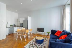 a living room with a blue couch and a table at DIFY Le Velvet - Bellecour in Lyon