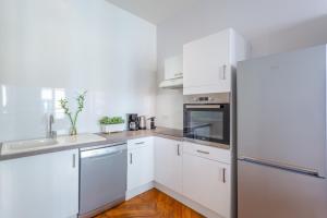 uma cozinha com armários brancos e um frigorífico em DIFY Le Velvet - Bellecour em Lyon
