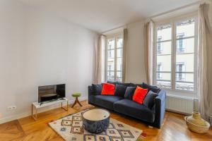 uma sala de estar com um sofá e uma televisão em DIFY Le Velvet - Bellecour em Lyon