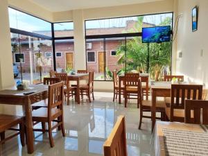 Villa Concepción的住宿－Hotel Karanda´y，餐厅设有桌椅和大窗户。