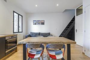 a kitchen and dining room with a wooden table and chairs at DIFY Tuileries - Valmy in Lyon