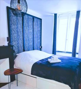 a bedroom with a bed and a table and a window at Au cœur des remparts, L'ÉCRIN Appartement 2 chambres pour 2-6 pers in Saint Malo