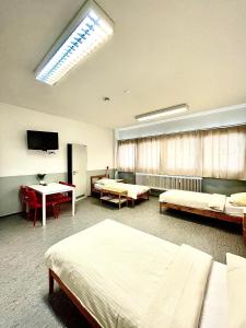 a hospital room with two beds and a tv at Pension Messe in Feldkirchen