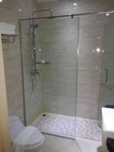 a shower with a glass door in a bathroom at Batam City Hotel in Nagoya