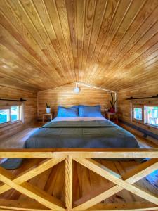 a bed in a wooden room with a wooden ceiling at Lazoğlu Bungalov in Guzelcamlı