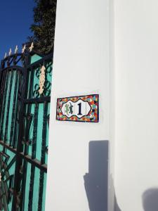 una señal en el lateral de un edificio con una puerta en The White House Lodges en Brufut