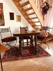 uma mesa e cadeiras num quarto com uma escada em La Romanée em Sallaumines