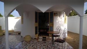 una stanza con tavolo e sedie in un edificio di The White House Lodges a Brufut