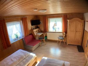 a living room with a bed and a desk and two windows at Zimmervermietung Ziegltrum in Wolfersdorf