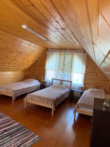 ゴルビツカヤにあるКоттеджи «Ласковый Берег»の木製天井のドミトリールームのベッド2台分です。