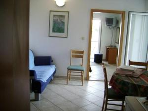 ein Wohnzimmer mit einem Sofa und einem Stuhl in der Unterkunft Apartment in Podgora with sea view, terrace, air conditioning, WiFi 3812-2 in Podgora