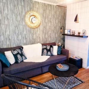 uma sala de estar com um sofá e uma mesa em Au cœur des remparts, L'ÉCRIN Appartement 2 chambres pour 2-6 pers em Saint Malo