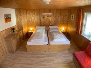 a bedroom with two beds in a wooden room at Zimmervermietung Ziegltrum in Wolfersdorf +12 photos