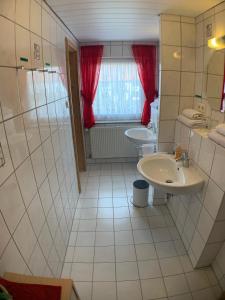 a white bathroom with two sinks and a window at Zimmervermietung Ziegltrum in Wolfersdorf