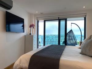 a bedroom with a large bed and a large window at Luxury Ocean Spa Plaza Private Large 1 bed apartment in Gibraltar