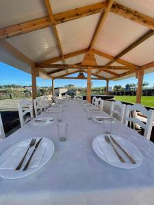 una mesa larga con platos blancos y cubiertos en Monte do Carapetal, en Amareleja