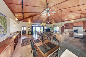 a large kitchen with a table and a dining room at Mele Kai in Keaau