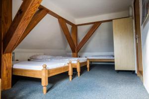 two beds in a room with wooden beams at Rýchorská bouda in Žacléř