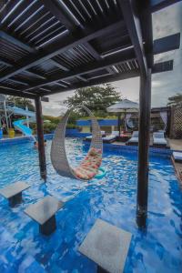 a swimming pool with two chairs in the water at Aimberê Eco Resort Hotel in Coqueiro