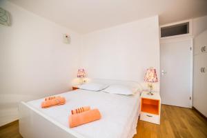 1 dormitorio con 1 cama blanca y 2 toallas de color naranja en Apartment in Bol with sea view, terrace, air conditioning, WiFi 3739-3 en Bol