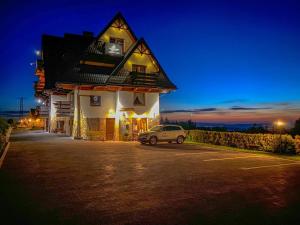 a car parked in front of a building at night at Willa w Gliczarowie in Gliczarów