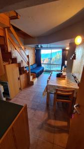 a living room with a table and a blue couch at Trilocale sulle piste con vista sulla ValdiSole in Marilleva