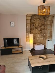a living room with a tv and a couch at Gîte Avalon - Closeries du Golfe in Theix