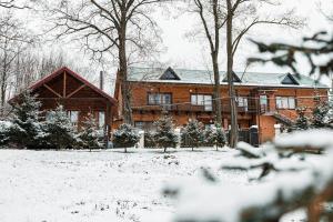 a large brick house with snow in front of it at Usadba Berezino in Zarvantsy
