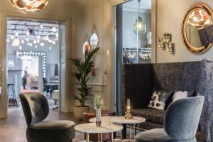 a lobby with chairs and tables and a couch at Såstaholm Hotell & Konferens in Täby