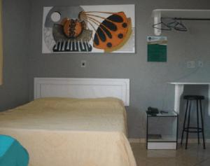 - une chambre avec un lit et une photo de papillon sur le mur dans l'établissement Hotel Graciosa Palace, à Palmas