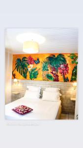 - une chambre avec 2 lits et un tableau mural dans l'établissement Village Pomme Cannelle, à Le Prêcheur