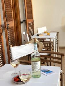 una botella de vino sentada en una mesa con dos copas en Anastasis Rental Rooms, en Skiathos