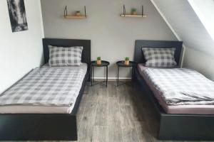 two beds in a room with two side tables at Work & Stay apartment Vohburg near Ingolstadt in Vohburg an der Donau