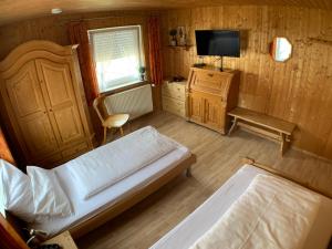 a bedroom with a bed and a tv and a chair at Zimmervermietung Ziegltrum in Wolfersdorf
