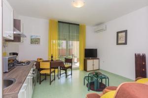 eine Küche und ein Wohnzimmer mit einem Tisch und Stühlen in der Unterkunft Two Bedroom Apartment Valdebecco for 5 persons in Pula