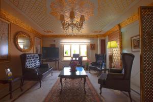 a living room with chairs and a table and a chandelier at Nasa Flora Hotel in Antalya