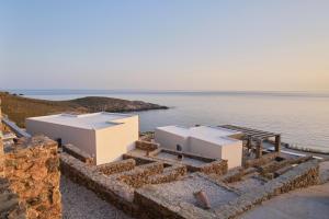 ein paar weiße Gebäude am Wasser in der Unterkunft Cape Suites in Kythnos