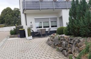 a house with a patio with a table and chairs at 2 Zimmer Appartements in Heroldsatt in Heroldstatt