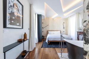 uma casa de banho com banheira e uma cama num quarto em Le Dortoir Boutique Suites em Nice