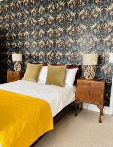 1 dormitorio con 1 cama y 2 mesitas de noche con lámparas en Rooms At The Rosebery, en Norwich