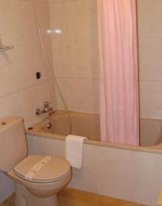 a bathroom with a toilet and a pink shower curtain at El Bouquet in Pla de l'Ermita