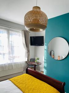 a bedroom with a mirror and a bed with a yellow blanket at Rooms At The Rosebery in Norwich
