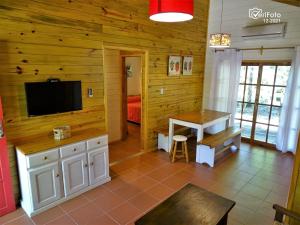 a living room with a television and a table at Villa Las Flores in Piriápolis